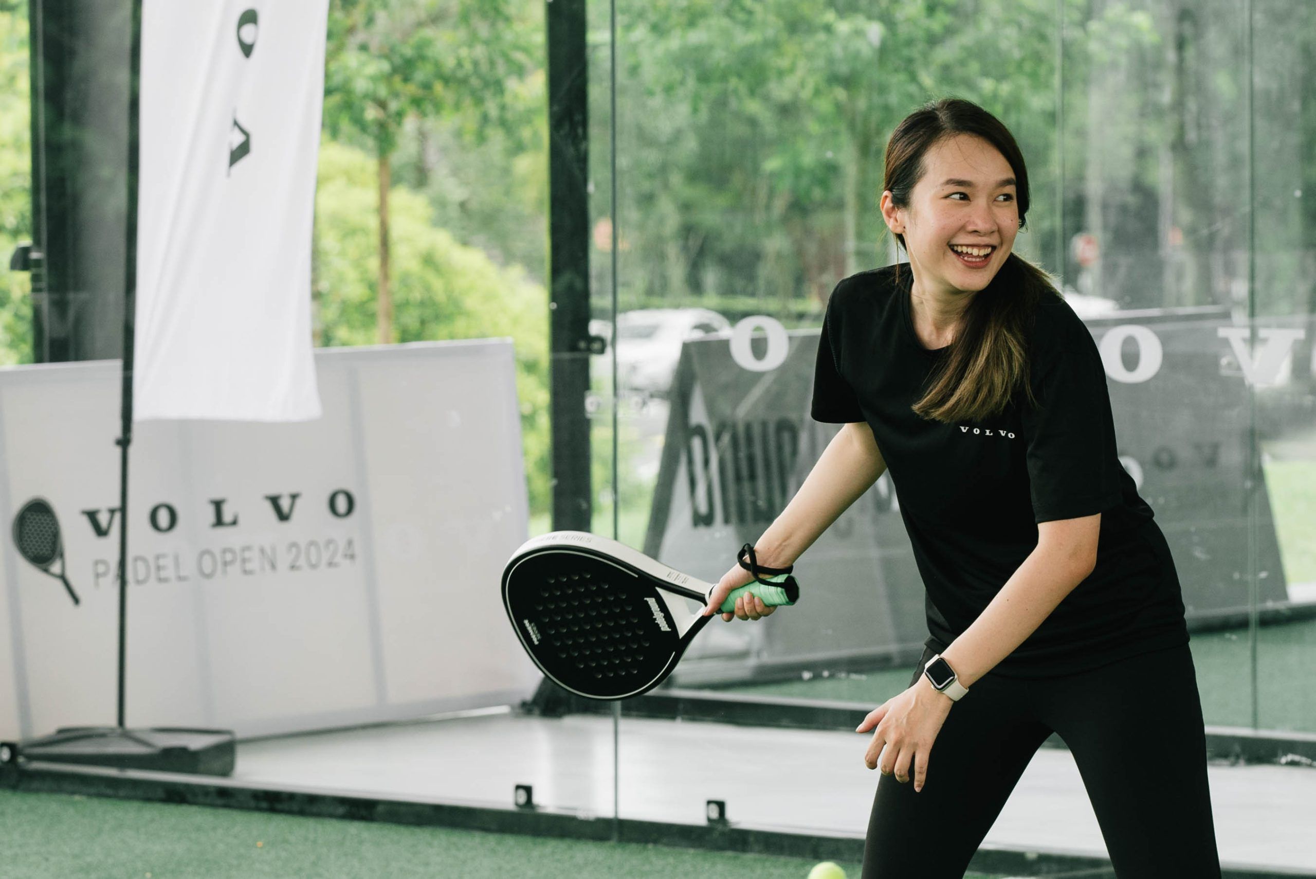 Padel players in action on glass-walled court in Malaysia